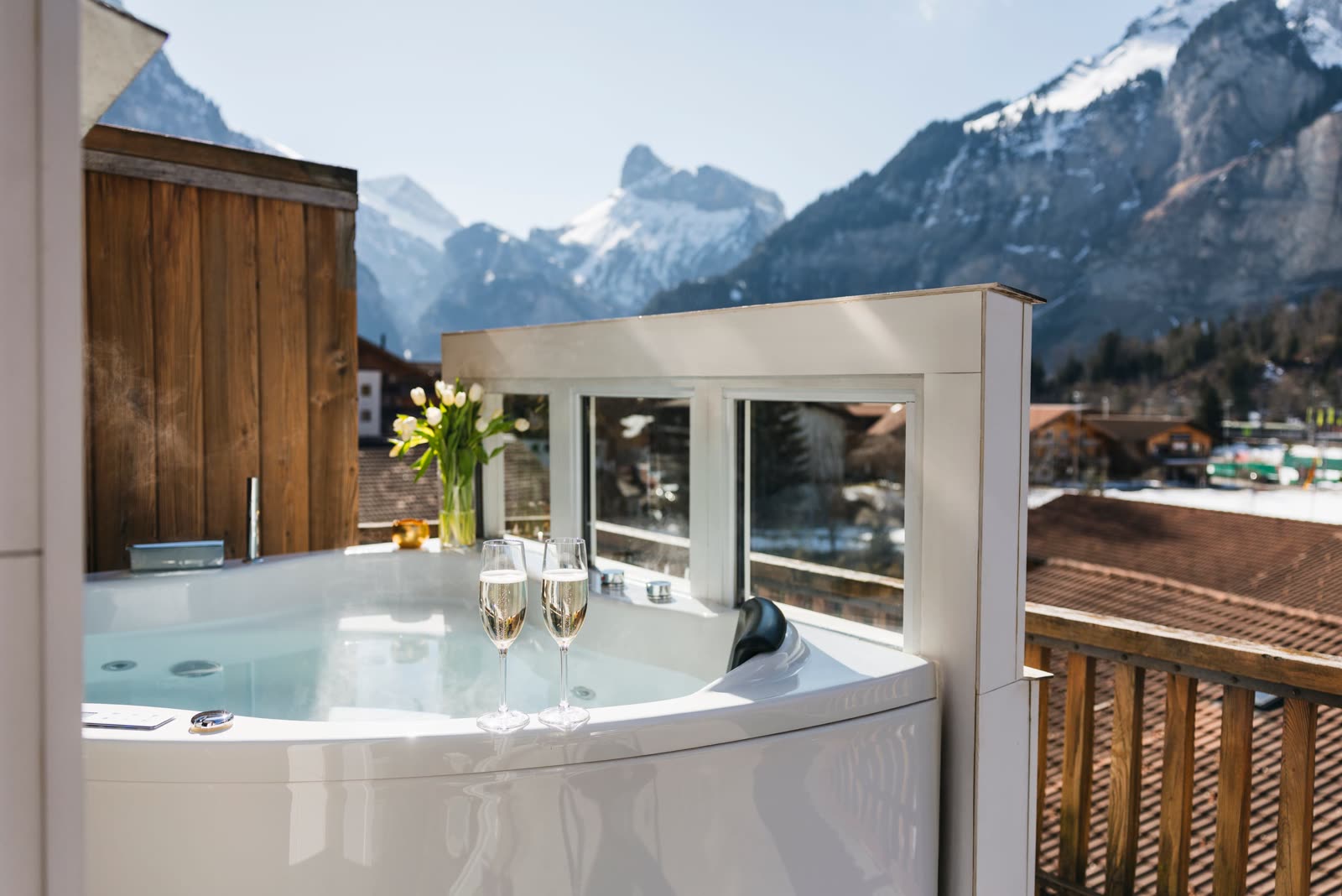 Whirlpool mit Champagnergläsern und Blick auf die Berge von Kandersteg